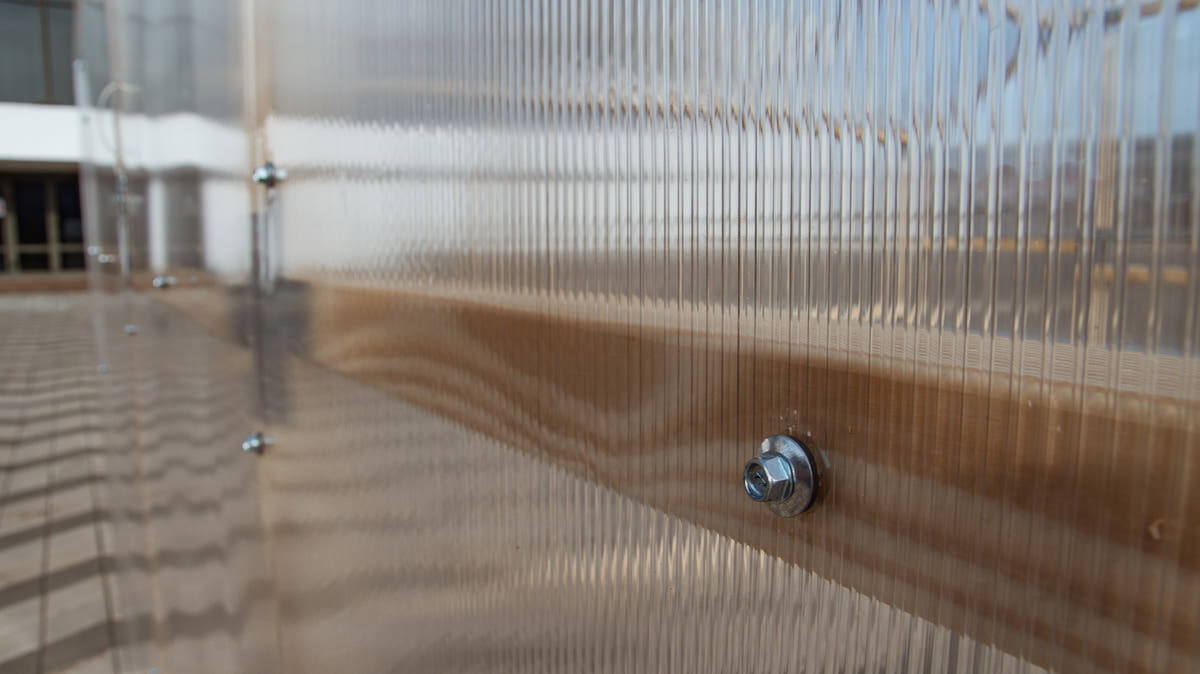 Twin-wall polycarbonate panel screw-fixed to the pine frame of a NORDIC greenhouse