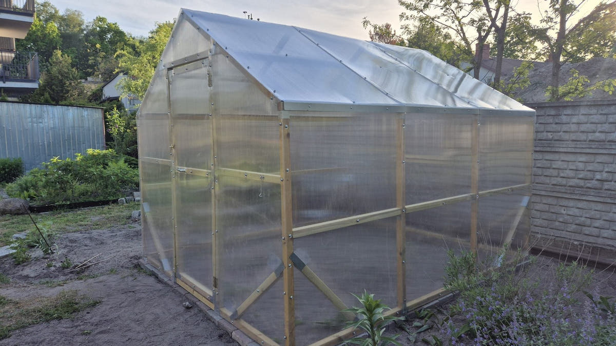 NORDIC wooden greenhouse with twin-wall polycarbonate standing in a back garden