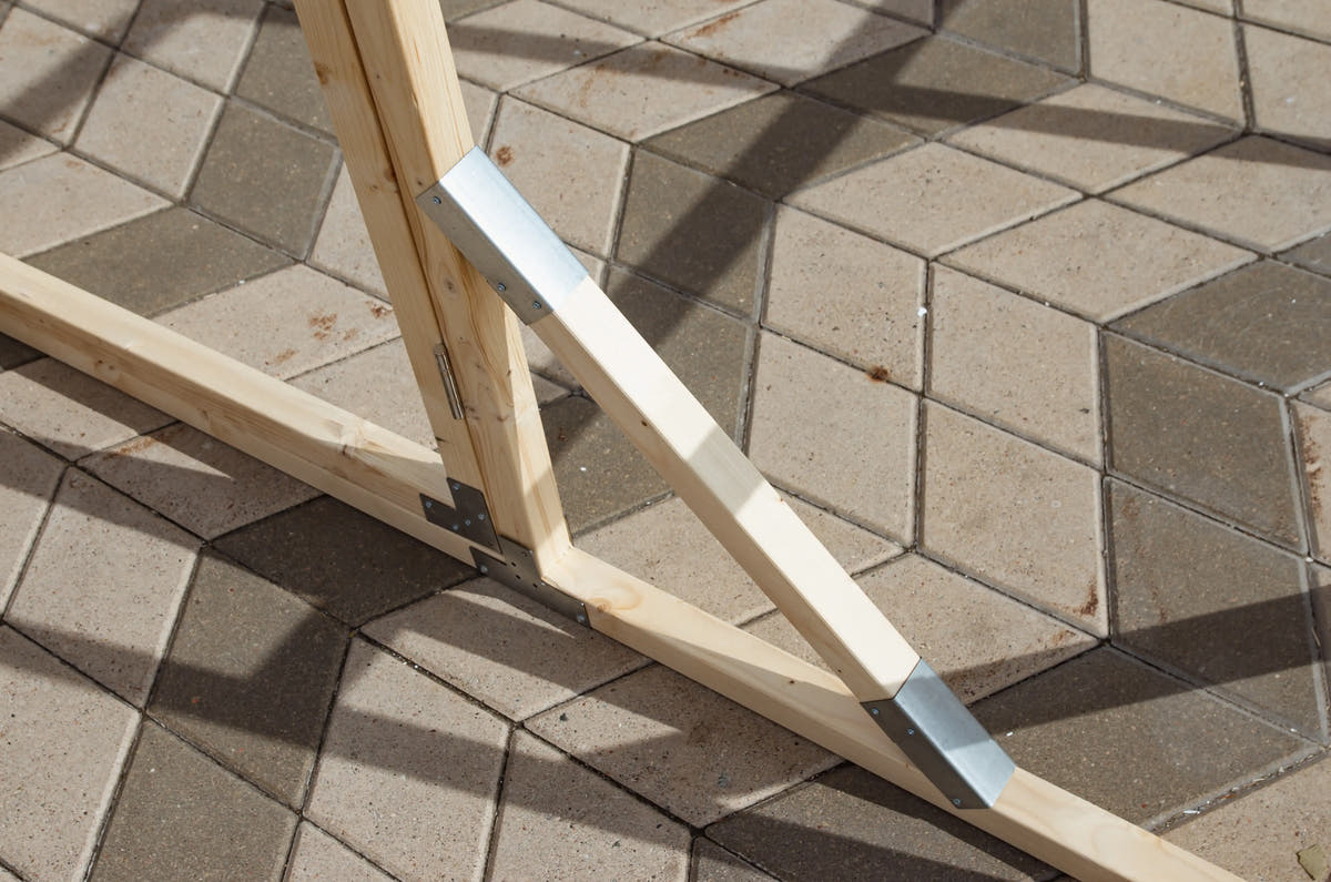 Corner of a NORDIC pine base frame with galvanised brackets, set on paving slabs
