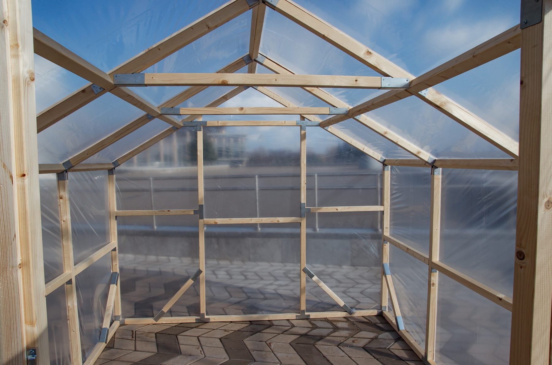 Inside an empty NORDIC greenhouse: pine frame, braces and walk-in headroom, ready for staging