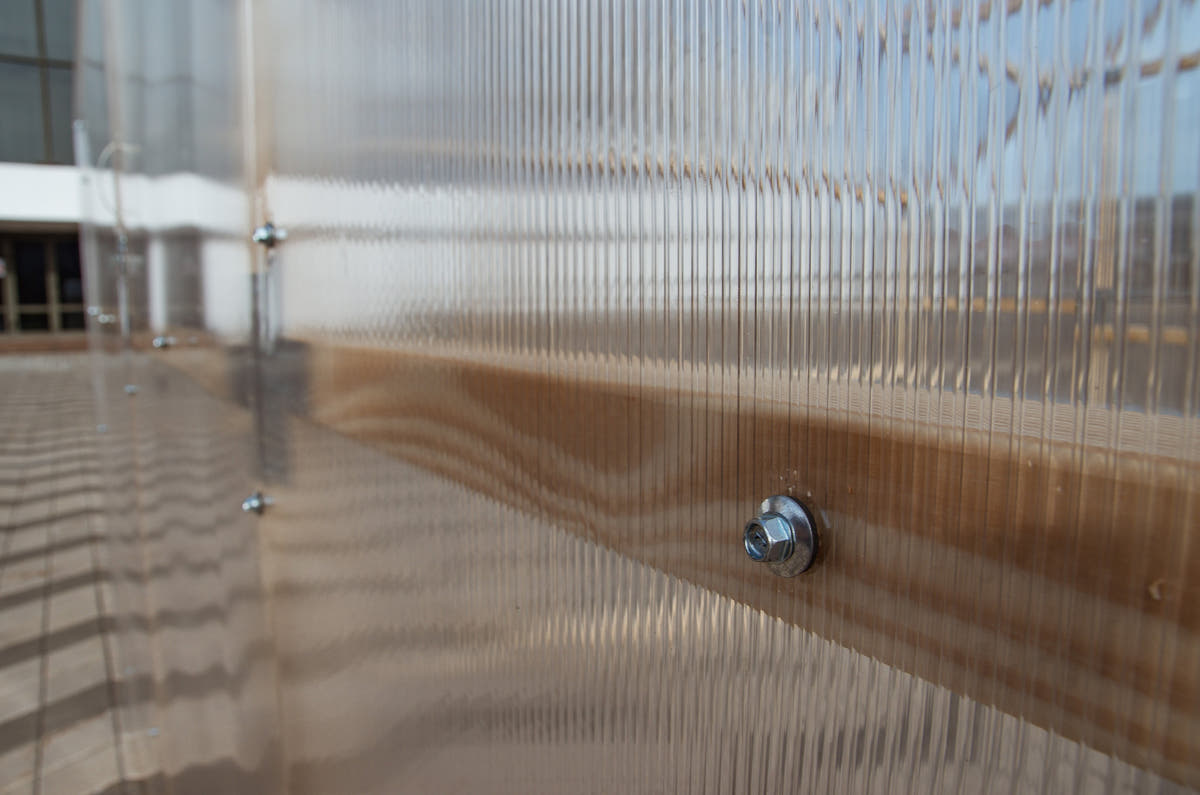 Twin-wall polycarbonate panel screw-fixed to the pine frame of a NORDIC greenhouse