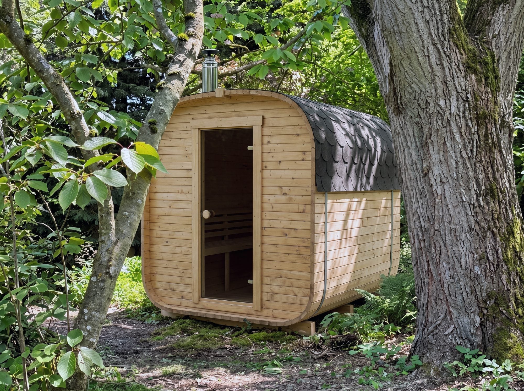 The Cabin Three compact outdoor sauna standing under a tree in a garden