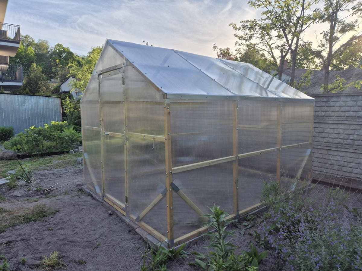 NORDIC wooden greenhouse with twin-wall polycarbonate standing in a back garden