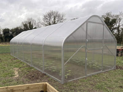 SteelRoot Gable 2.77 greenhouse, straight walls under a pitched roof, on a lawn