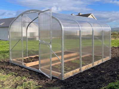 SteelRoot Garden 2.64 greenhouse with the door open on freshly dug ground