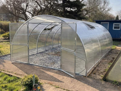 SteelRoot Grand 4.00 greenhouse with both doors open on a gravel path