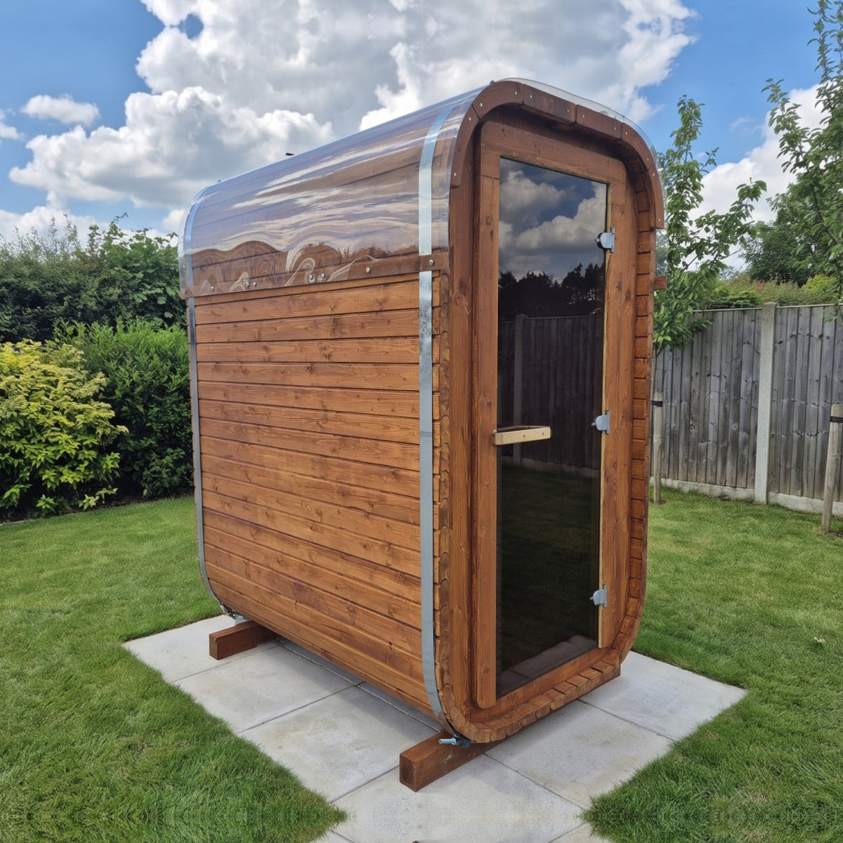 The Slim Two electric sauna, three-quarter view: the glass door, the clear roof cover and the side wall