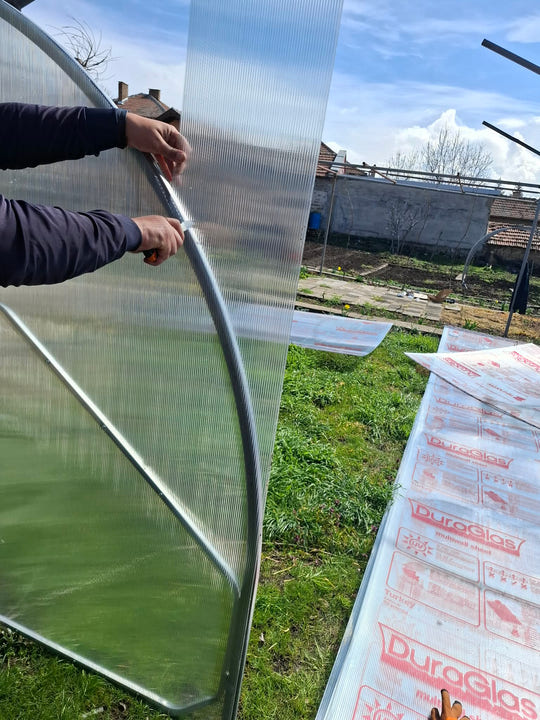 Trimming the polycarbonate sheet back to the arch with a knife
